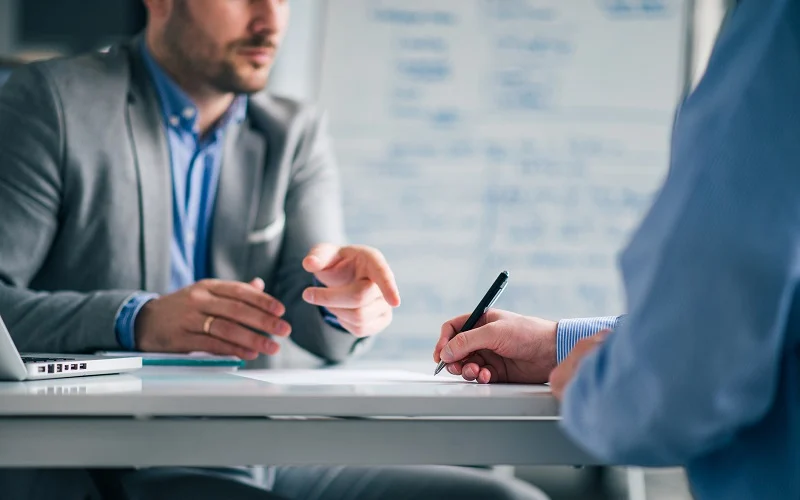 Business people negotiating, signing a contract, close up.