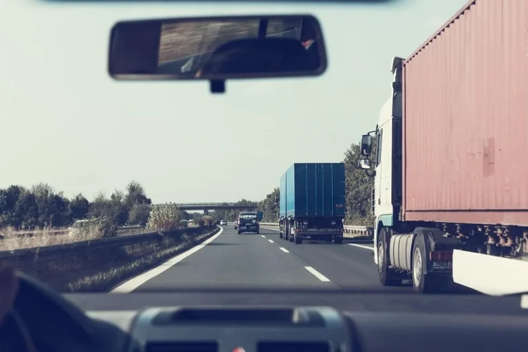Vehicles on a highway with two trucks on the road