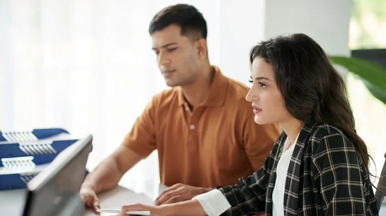 A young couple sites at a table in an office