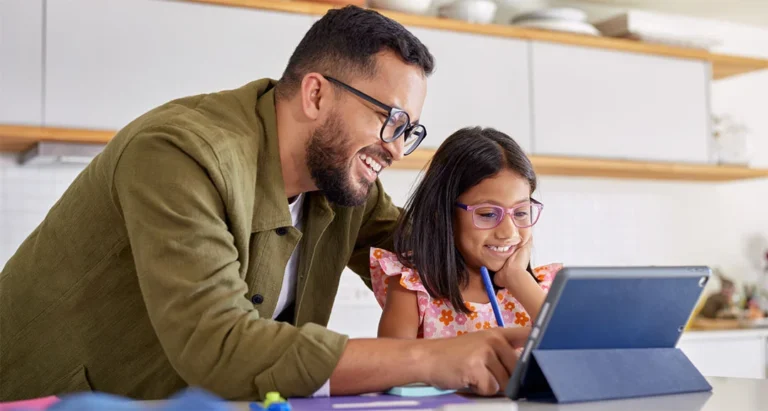 A father and daughter look at a tablet together