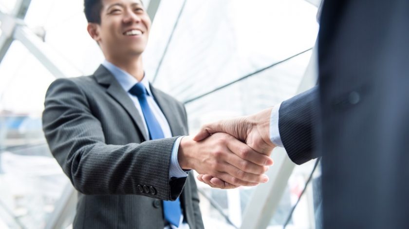 Young businessman leader making handshake with partner - greeting, dealing, merger and acquisition concepts