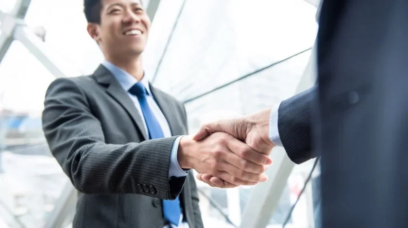 Young businessman leader making handshake with partner - greeting, dealing, merger and acquisition concepts