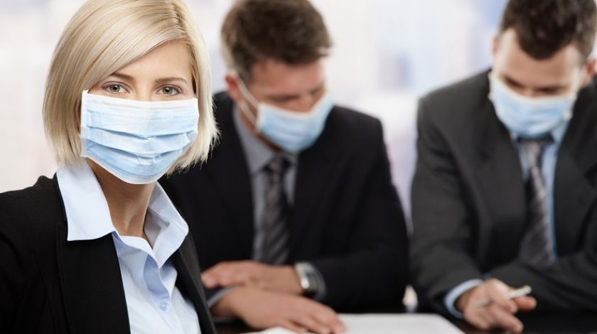 Businesswoman fearing h1n1 swine flu virus wearing protective face mask during meeting at office. Click here for more Business images: