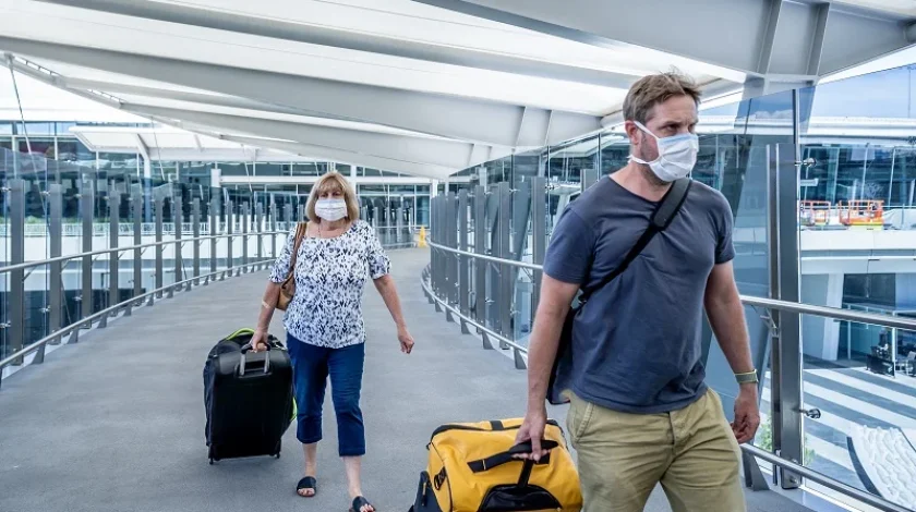 Senior woman and adult son wearing face mask at airport in fear of coronavirus and travel ban and international trips cancellations for disease control and prevention of COVID-19 outbreak pandemic.