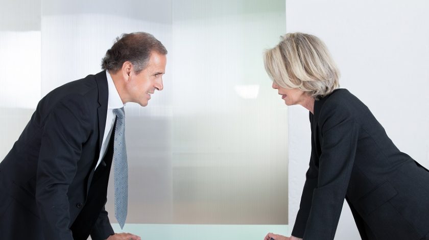 Mature Businessman And Businesswoman Looking At Each Other With Angry