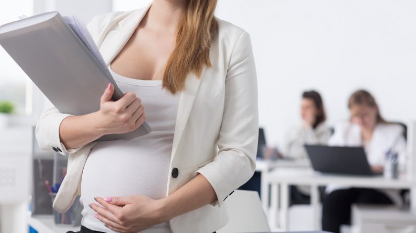 Female chief in pregnancy working in the office