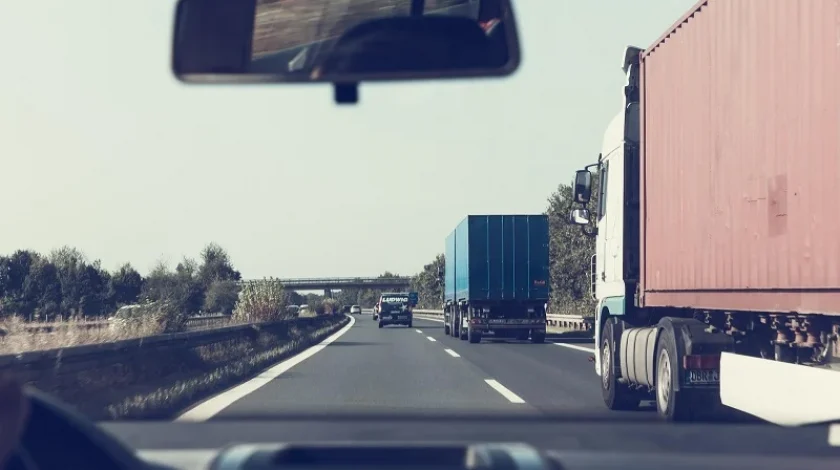Vehicles on a highway with two trucks on the road