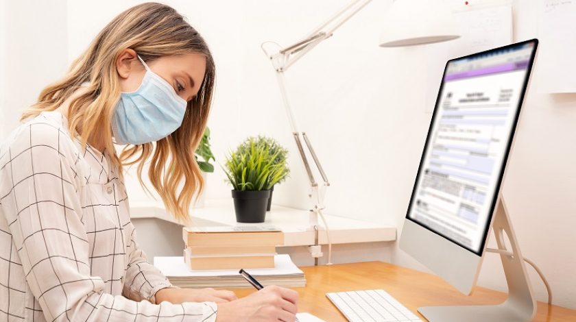 Young business woman working from home wearing protective mask