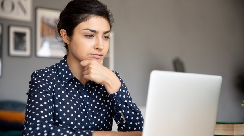 Woman on laptop focused and concentrating