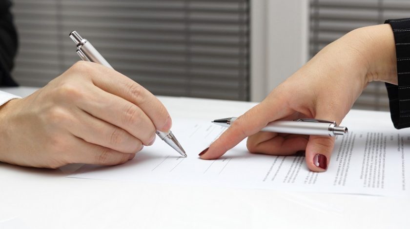 businesswoman point with finger on paper to sign up contract