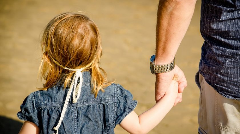 Little girl holding a male's hand. This could be her father, or a pedophile.
