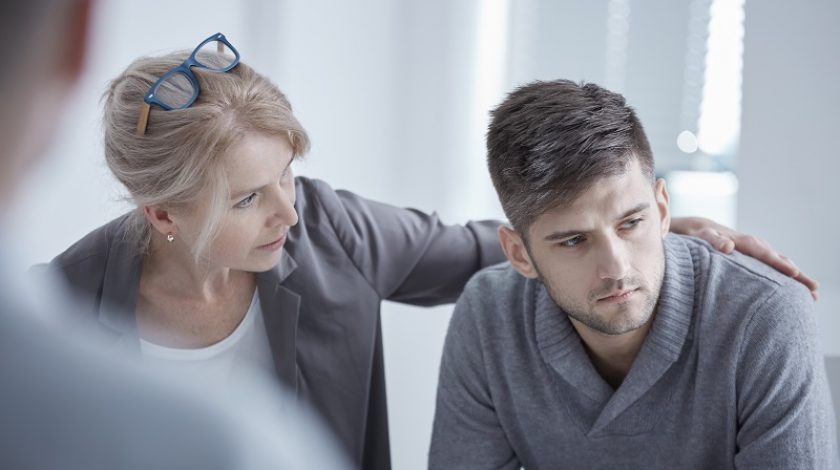 Psychologist supporting young man suffering from depression